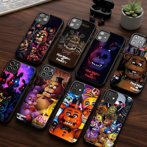 May include: A collection of phone cases featuring various characters from the "Five Nights at Freddy's" video game series. The cases display colorful illustrations of the characters, with some cases also including the game's logo and text.