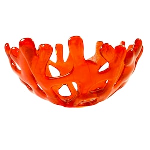 May include: Orange glass bowl with a coral-like design. The bowl is made of clear glass with a textured surface.