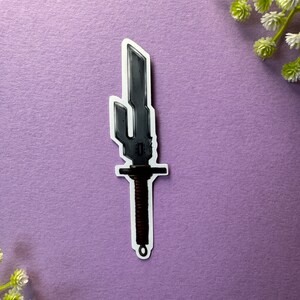 May include: A silver-coloured sword with a black handle and a decorative design on the blade. The sword is on a purple background.