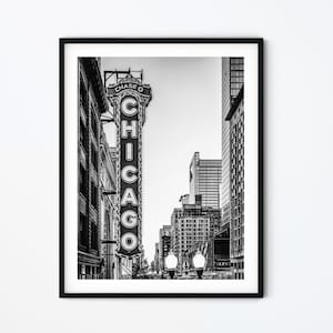 Può includere: Una fotografia in bianco e nero di una strada cittadina a Chicago, Illinois. La foto presenta un grande cartello che recita "CHASE O CHICAGO" in lettere bianche su sfondo nero. Il cartello è montato su un edificio ed è visibile dalla strada. La foto mostra anche altri edifici e lampioni.