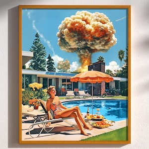 Op de afbeelding: Een ingelijste print toont een vrouw die ontspant bij een zwembad met een oranje parasol, een modern huis uit het midden van de eeuw en een paddenstoelwolk op de achtergrond. Het kunstwerk heeft een retro, vintage esthetiek met levendige kleuren.