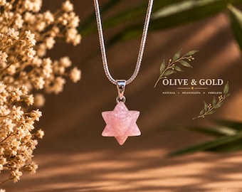 May include: A silver-toned snake chain necklace featuring a six-pointed star pendant carved from translucent pale pink rose quartz. The pendant is suspended from a simple silver bail. The text OLIVE & GOLD NATURAL MEANINGFUL TIMELESS is visible.
