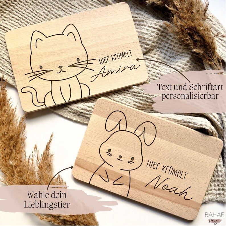 May include: Two wooden cutting boards with a cat and bunny design. The boards are personalized with the text "Hier Kr&uuml;melt" and a name. The text and font can be customized.