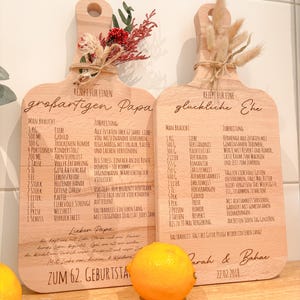 May include: Two wooden cutting boards with engraved recipes, one for a "great Dad" and the other for a "happy marriage." Each board is decorated with dried flowers and tied with twine. A lemon sits in front.