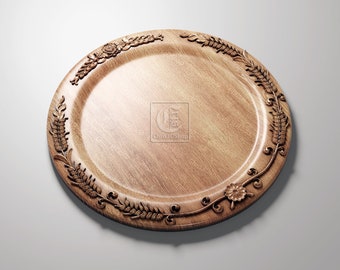 May include: A round wooden serving tray with a carved floral design around the edge. The tray is light brown in color and has a smooth, polished finish.