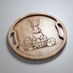May include: A wooden serving tray with a carved design of a rabbit sitting in a basket of eggs. The tray has two handles and is oval shaped.