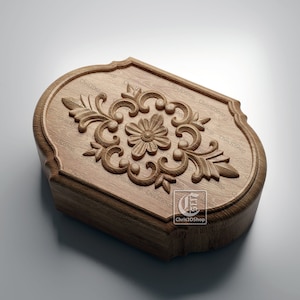 May include: A wooden box with a carved floral design on the top. The box is oval shaped and has a rounded edge. The carving is intricate and detailed, with a central flower surrounded by leaves and swirls.