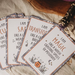 Puede incluir: Cinco tarjetas de afirmaci&oacute;n con fondo gris y texto naranja. Las tarjetas presentan frases como "Yo soy Focus" e "Yo soy Magic".