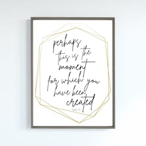 May include: Framed art print with the quote "perhaps this is the moment for which you have been created" in black script. The text is inside a gold geometric design on a white background, framed in gray.