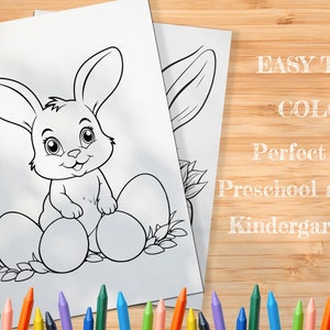 Op de afbeelding: Zwart-witte kleurplaat met een cartoon konijn dat op drie paaseieren zit. Het konijn heeft grote oren en lacht. De tekst "EASY TO COLOR" en "Perfect for Preschool and Kindergarten" staat in wit op een houten achtergrond.