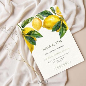 以下が含まれることがあります： 水彩画のレモンと葉が特徴の結婚式の招待状。「JULIA & TIM ARE GETTING MARRIED」と日付と時刻が記載されています。デザインにはレモンの枝が含まれており、クリーム色の背景に設定されています。
