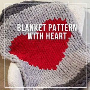 Puede incluir: Una manta de punto gris y roja con una forma de corazón en el centro. La manta tiene una textura de punto grueso y el texto "BLANKET PATTERN WITH HEART" está escrito en la parte superior.