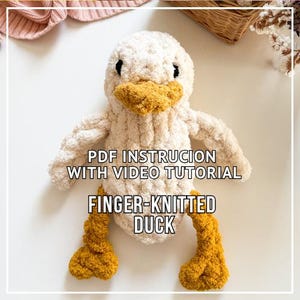 May include: A finger-knitted duck toy with a fluffy, cream-coloured body, a yellow beak and feet, and black eyes. The text "PDF INSTRUCTION WITH VIDEO TUTORIAL FINGER-KNITTED DUCK" is displayed on the front of the toy.
