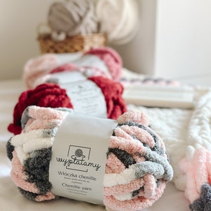 Op de afbeelding: Een close-up van een roze, witte en grijze chenille garenbal met een label met de tekst "Włóczka chenille" en "Chenille yarn".