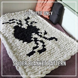 Puede incluir: Una manta de punto grueso de color crema con un gran diseño de araña negra. La manta tiene el texto "PDF MOTIF ONLY" y "SPIDER BLANKET PATTERN" en negro. La manta está doblada sobre una cama.