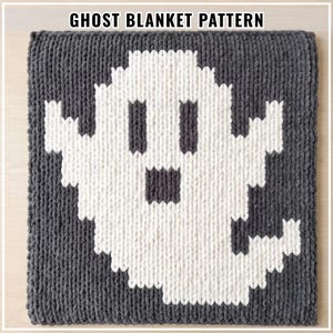 May include: A square crochet blanket featuring a pixelated ghost design in white yarn against a dark grey background. The text GHOST BLANKET PATTERN is displayed at the top. The blanket is constructed with a thick, chunky yarn texture throughout.