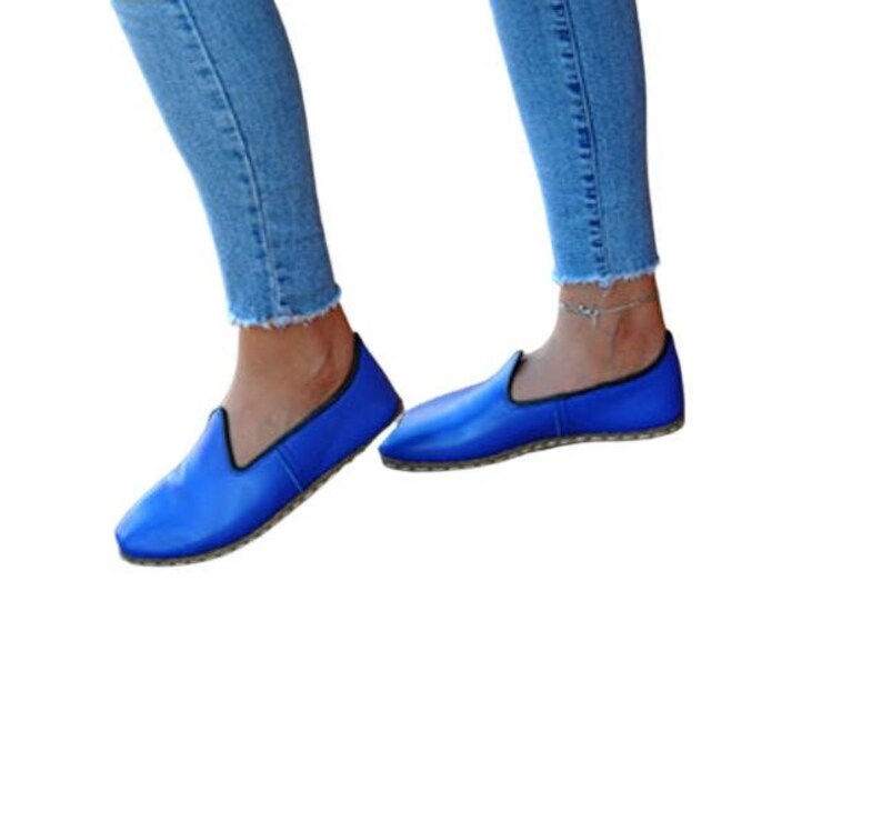 May include: A pair of blue leather slip-on shoes with a flat sole.
