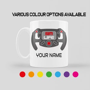 May include: White ceramic mug featuring a grey steering wheel graphic and the text "Sim Life" in red. The mug also has the text "Your Name" printed on the bottom. The mug is available in a range of colours.