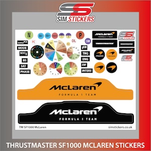Puede incluir: Un conjunto de pegatinas para volante de carreras Thrustmaster SF1000 del equipo McLaren de Fórmula 1. Las pegatinas son negras, naranjas y blancas y presentan el logotipo de McLaren, el nombre del equipo y el logotipo de Thrustmaster.