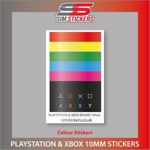 May include: A sheet of colourful stickers for PlayStation and Xbox consoles. The top section features horizontal stripes in rainbow colours. Below are black circles with coloured symbols and letters. Text on the sticker reads "PLAYSTATION & XBOX ROUND 10mm" and "simstickers.co.uk".