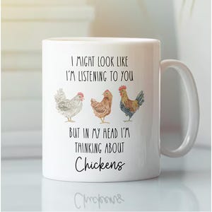 May include: White ceramic mug with a humorous quote and chicken illustrations. The mug features the text "I MIGHT LOOK LIKE I'M LISTENING TO YOU BUT IN MY HEAD I'M THINKING ABOUT Chickens" with three watercolor chicken images.