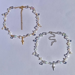 May include: Two delicate necklaces with iridescent star charms and crystal beads. Each necklace features a gold or silver star pendant.