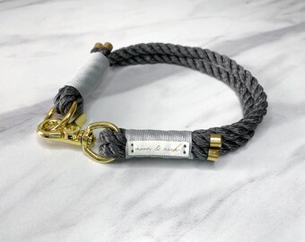 Op de afbeelding: Grijze touwhalster voor honden met gouden hardware en een wit leren label met de tekst "moon & neck".