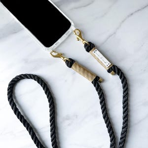 chaîne de téléphone portable noire « Iconic » avec mousqueton doré et emballage doré avec étui pour téléphone portable