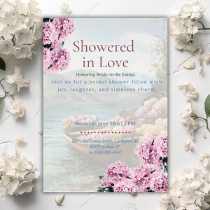 May include: A bridal shower invitation with the text "Showered in Love" and details for the event. The design features a watercolor illustration of a boat on a lake, surrounded by pink flowers and white hydrangeas.