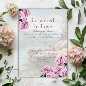 May include: A baby shower invitation with the text "Showered in Love" and floral accents. The invitation features a watercolor scene of a boat on a lake, with pink flowers and greenery surrounding the text.