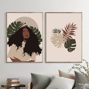May include: Two framed prints with a minimalist design. The first print features a woman with long curly hair and a tropical leaf design. The second print features a tropical leaf design in shades of green, brown, and beige.