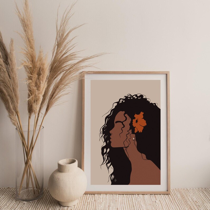 May include: A digital art print featuring a woman with long, curly black hair and a single orange flower behind her ear. The background is a light beige color.