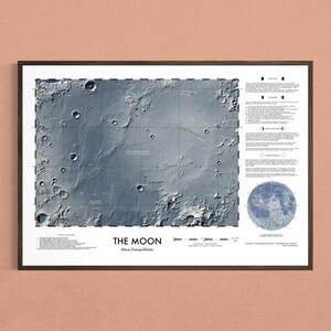 May include: A framed wall print titled THE MOON Mare Tranquillitatis featuring a detailed gray lunar surface map with craters, grid lines, and descriptive text blocks. The print includes a circular moon diagram and a scale bar at the bottom.