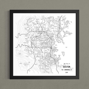 May include: A framed black and white map print of the city of Boston, featuring intricate topographical contour lines, road networks, and water bodies. The text in the bottom right corner reads The City of BOSTON THE COMMONWEALTH 2287.