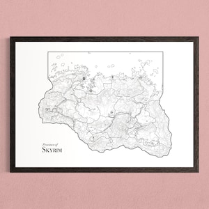 May include: A framed black and white line art map of the Province of Skyrim. The print features detailed topographical outlines, geographical landmarks, and icons representing various locations, with the text Province of SKYRIM in the bottom left.