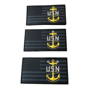 May include: Three black and gray embroidered patches with the US Navy anchor and the letters USN. The patches are rectangular and have a black border.