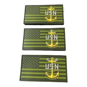 May include: Three green and yellow embroidered patches with the American flag and the words "USN" and an anchor.