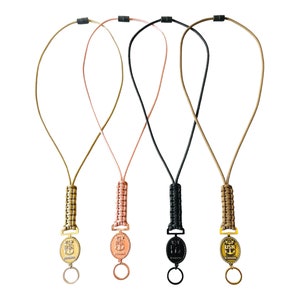 May include: Three paracord lanyards with gold, black, and brown braided cords and gold metal keychains with an anchor design. The keychains have the text "USN" on the gold keychain.