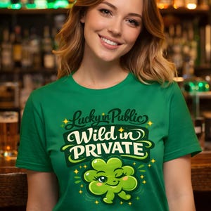Puede incluir: Una camiseta verde con el texto "Lucky in Public, Wild in Private" y un trébol. El diseño presenta una fuente juguetona y estrellas, perfecta para el Día de San Patricio o para uso diario.