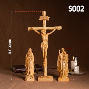 May include: A set of three wooden religious figurines, including a crucifix with the inscription "INRI", a statue of the Virgin Mary, and a statue of Saint Joseph with the baby Jesus. The figurines are all carved from wood and have a natural finish. The crucifix is 11.8 inches (30 cm) tall, and the other two figurines are 5.9 inches (15 cm) tall.