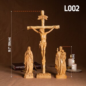 May include: A wooden crucifix with a carved figure of Jesus Christ, a wooden statue of the Virgin Mary, and a wooden statue of Saint Joseph with the baby Jesus. The crucifix is 19.7 inches tall and the statues are 11.8 inches tall.