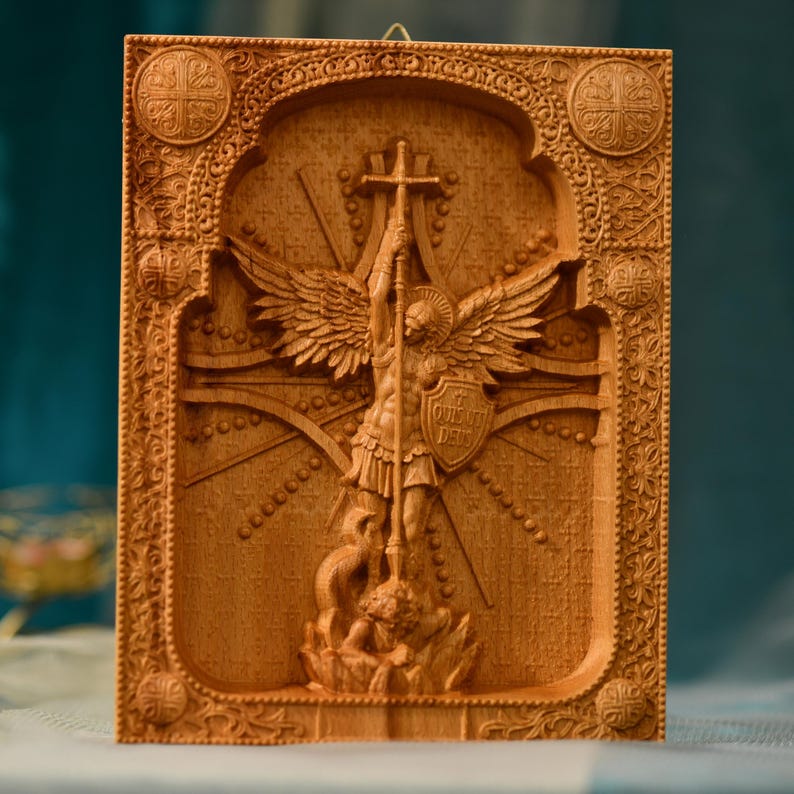 May include: A wooden carving of the Archangel Michael, a warrior angel with wings, holding a spear and shield. The carving is detailed and intricate, with a cross behind the angel and a dragon at the base.