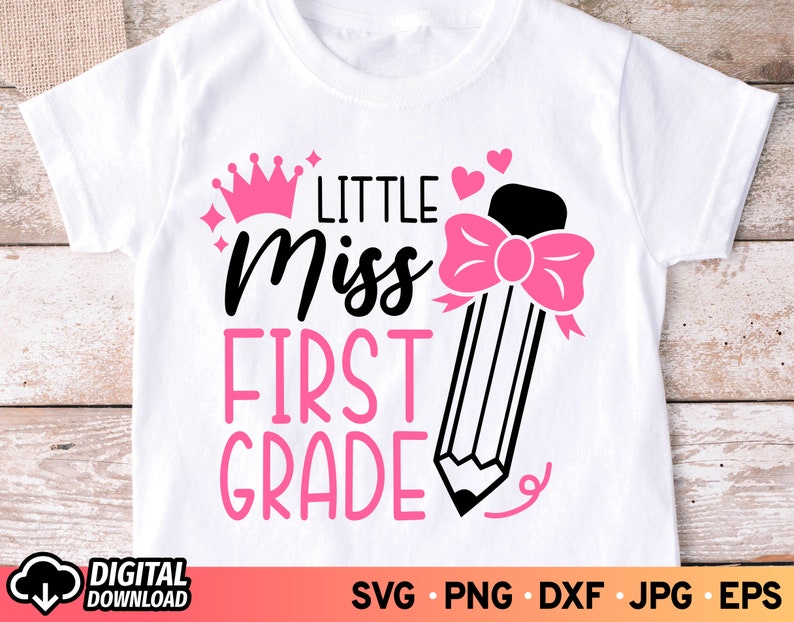 May include: White t-shirt with pink text that reads "Little Miss First Grade" and a pink crown and pencil with a pink bow.