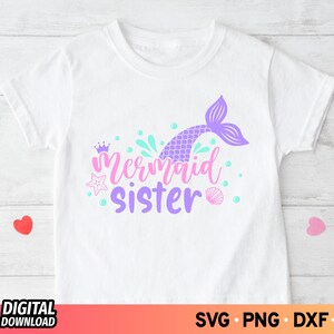 May include: A white t-shirt with a purple mermaid tail, a crown, and the text "Mermaid Sister" in purple.