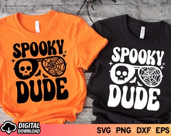 Puede incluir: Dos camisetas con un diseño espeluznante. La camiseta naranja tiene texto negro que dice "Spooky Dude" con un diseño de calavera y telaraña. La camiseta negra tiene texto blanco que dice "Spooky Dude" con un diseño de calavera y telaraña.