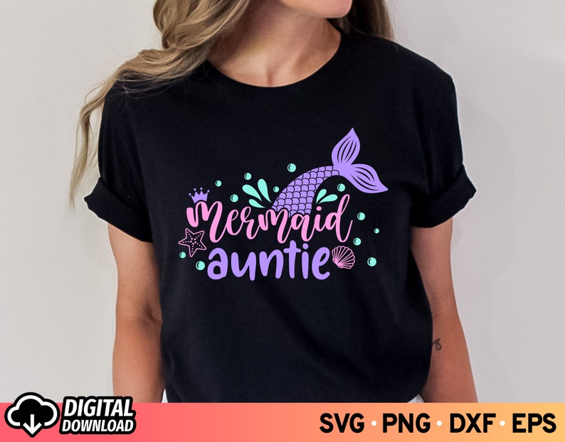 May include: Black t-shirt with a purple mermaid tail and the text "Mermaid Auntie" in pink and purple lettering. The design also includes a crown, a starfish, and seashells.