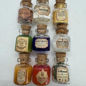 May include: Nine small glass potion bottles with cork stoppers. Each bottle contains a different colored liquid or substance and has a label with a unique name, such as "Mandrake" and "Felix Felicis". The bottles are arranged in three rows of three.
