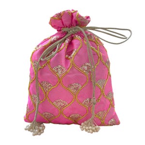 Puede incluir: Un bolso rosa brillante con cordón, bordado dorado y detalles de lentejuelas. El bolso tiene un cierre de cordón dorado y detalles de borlas. Hecho de tela brillante, es adecuado para llevar objetos pequeños.