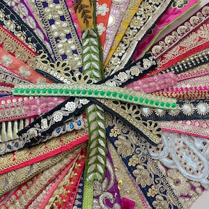 May include: A collection of colorful embroidered ribbons in various widths and designs. The ribbons feature gold, silver, and colorful thread with sequins and beads. The ribbons are arranged in a radial pattern, showcasing the variety of textures and colors.