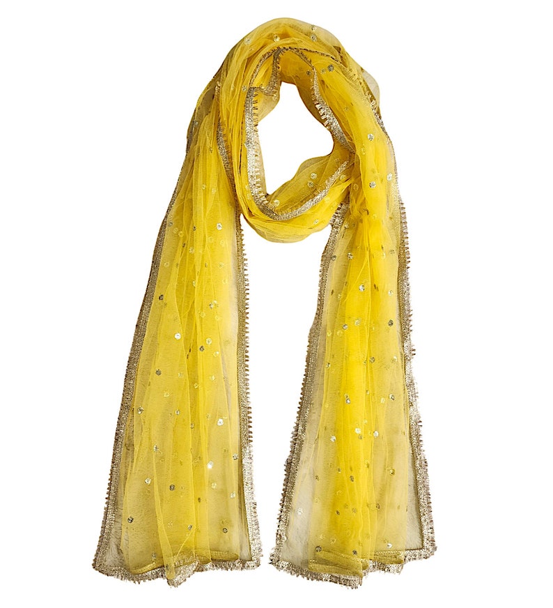 May include: A yellow sheer scarf with a gold trim and sequins. The scarf is folded in half and has a loop at the top.
